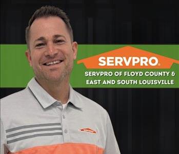 Man smiling, wearing a SERVPRO shirt, on a black background and a SERVPRO logo